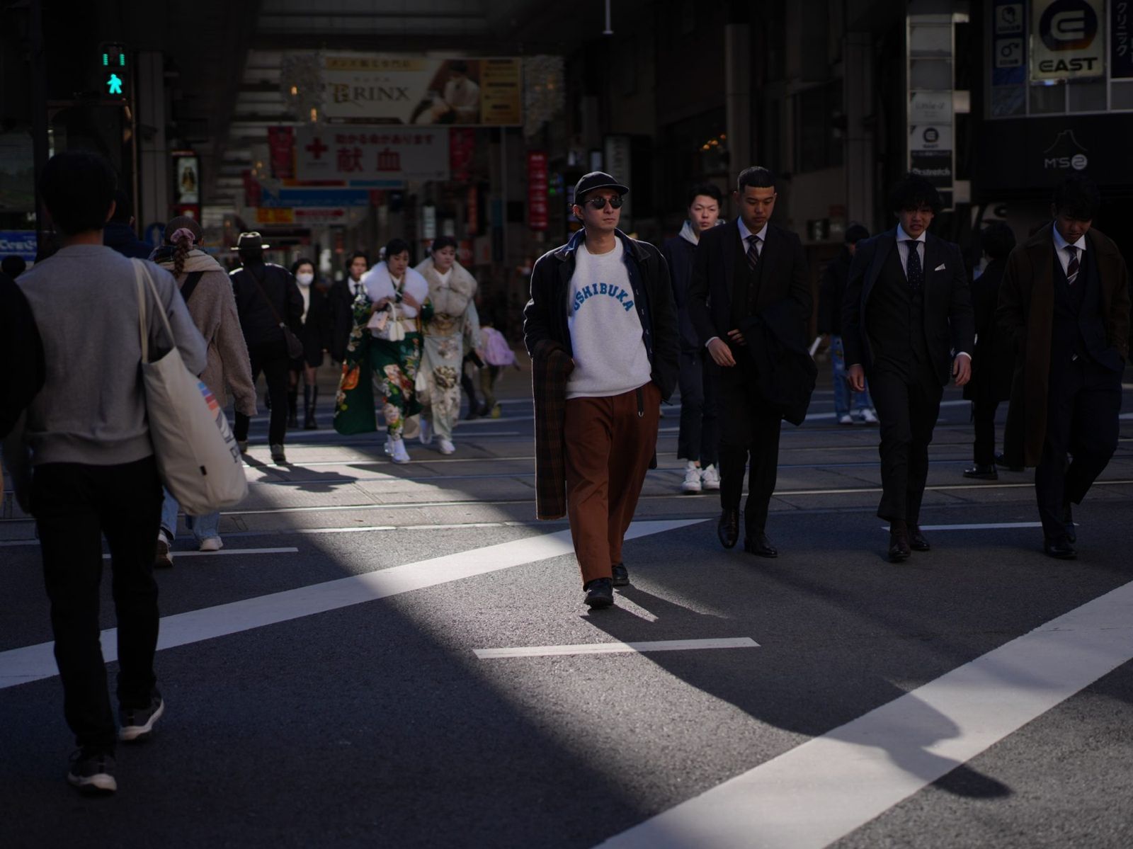 USHIBUKAスウェットで交差点を歩く男性