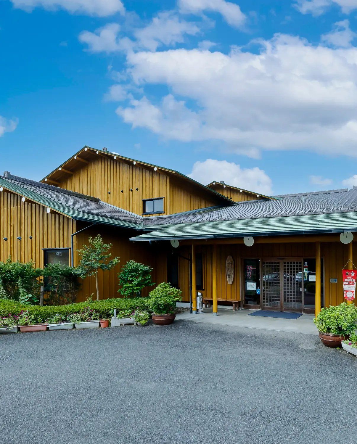 木の外壁と緑の屋根のやすらぎ荘の玄関