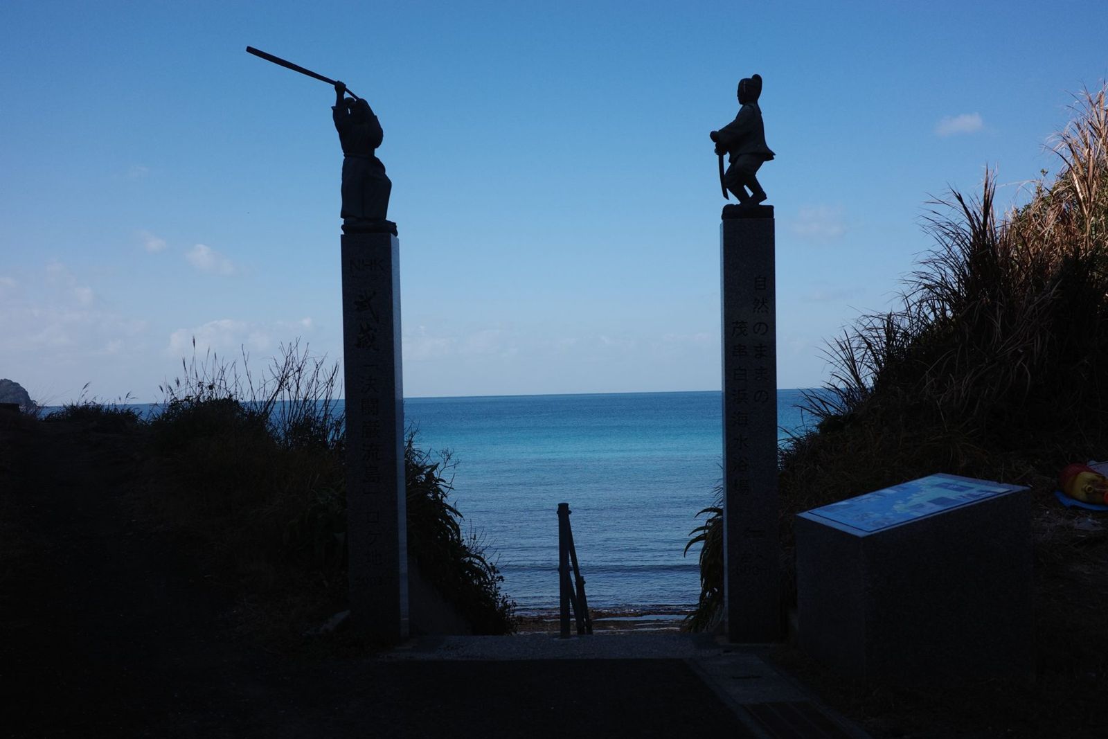 海へ下りる階段の両側に立つ、武蔵と小次郎の像